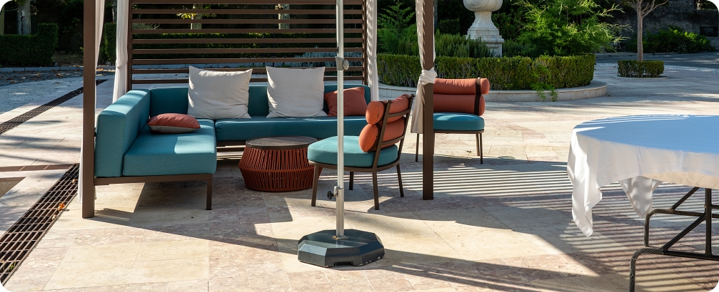 Modern outdoor furniture with umbrella on paved marble patio or courtyard
