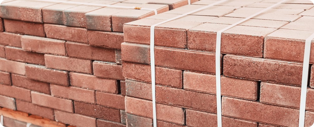 pallets and packages of freshly produced red bricks in a construction warehouse on the street. Concept of repair and building materials