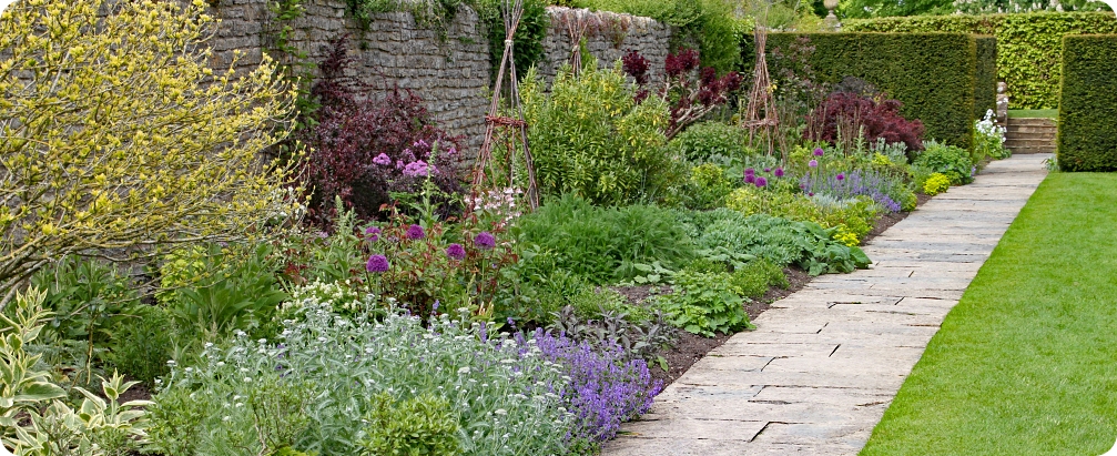 Stone flag path in front of a herbaceous border at an English country garden