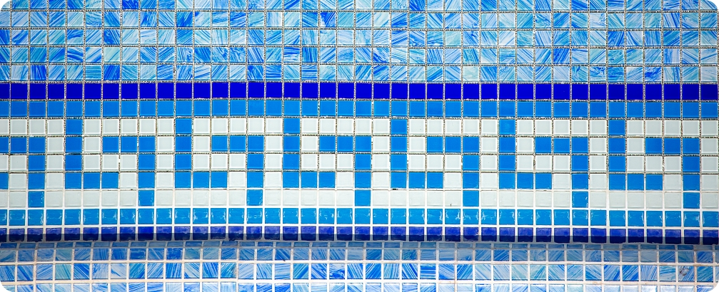 Background of pool wall with ceramic mosaic tiles. Beautiful decor for the bathroom, blue tiles with a Greek pattern.